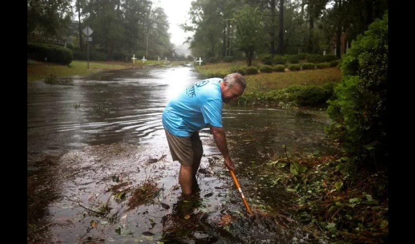 vecino intentan limpiar una calle inundada tras el paso del huracán Florence, en Wilmington, Carolina del Norte. EFE 