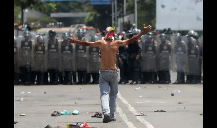 Manifestantes opositores se enfrentan a la Policía venezolana, en el Puente Internacional Simón Bolívar, este sábado, en Cúcuta (Colombia). La Policía venezolana impidió este sábado el paso del cordón humanitario que pretendía acompañar desde la ciudad colombiana de Cúcuta a varios camiones con ayuda humanitaria para Venezuela por el fronterizo Puente Internacional Simón Bolívar. EFE/Ernesto Guzmán Jr.