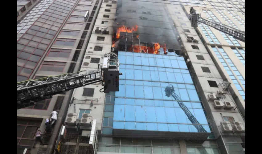 Miembros del cuerpo de bomberos de Bangladesh intentan apagar el incendio que se ha producido en un edificio, este jueves en Dacca (Bangladesh).