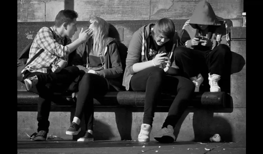 Foto ilustrativa de un grupo de jóvenes compartiendo entre sí. 