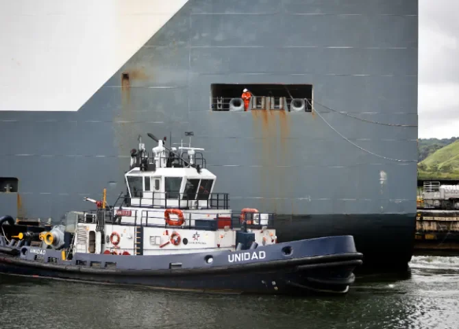  n barco remolcador realiza maniobras durante el tránsito de un buque de carga por las esclusas de Pedro Miguel. Foto: EFE 