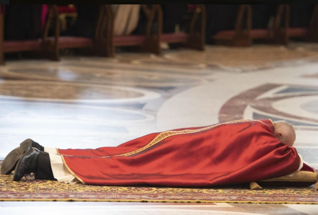 El papa Francisco se tumba para rezar durante la ceremonia de la Pasión del Señor./ EFE