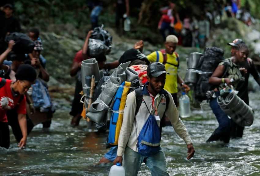 Fotografía del 28 de septiembre de 2021 que muestra a migrantes haitianos en su camino hacia Panamá por el Tapón del Darién en Acandi (Colombia). EFE