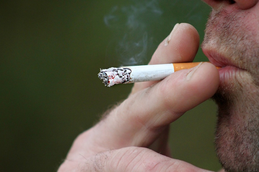 Una persona mientras se fuma un cigarrillo.  