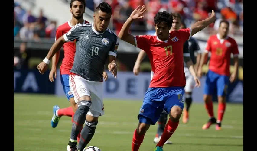 Dario Lezcano (19) de Paraguay controla el balón ante el acoso de Yeltsin Tejeda (17) de Costa Rica. AP
