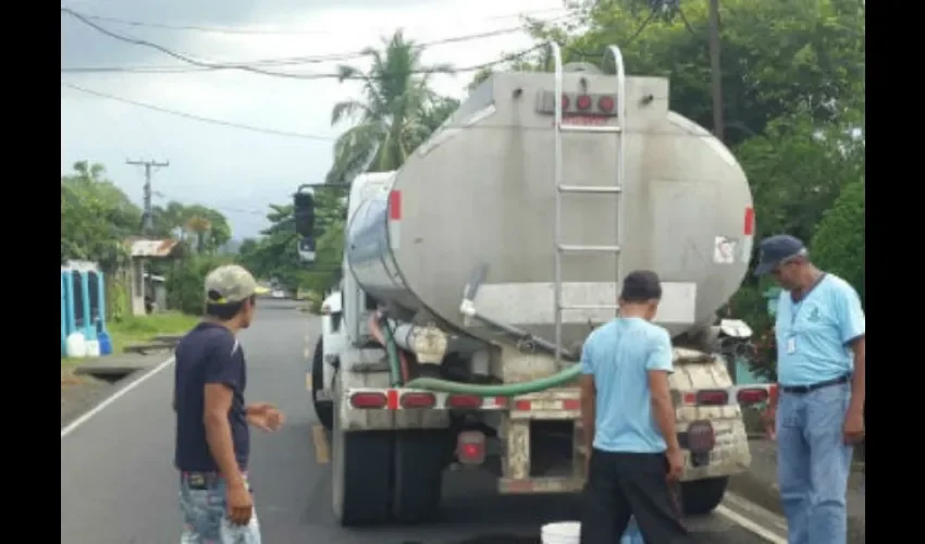 Foto ilustrativa de personal del Idaan entregando agua por el carro cisterna. 