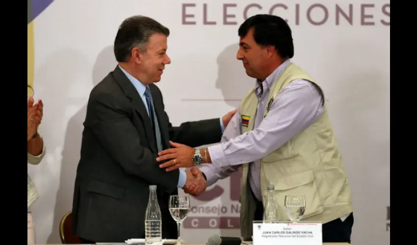 El presidente de Colombia, Juan Manuel Santos (i), estrecha la mano del registrador nacional de Colombia, Juan Carlos Galindo (d), durante la instalación Misión de Observación Electoral Internacional para los comicios legislativos.