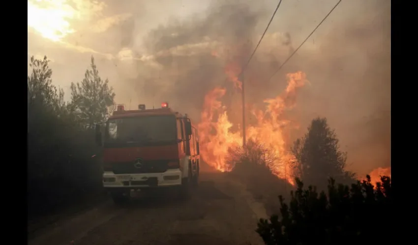 Bomberos tratan de extinguir un incendio en Penteli, al norte de Atenas. Foto: EFE