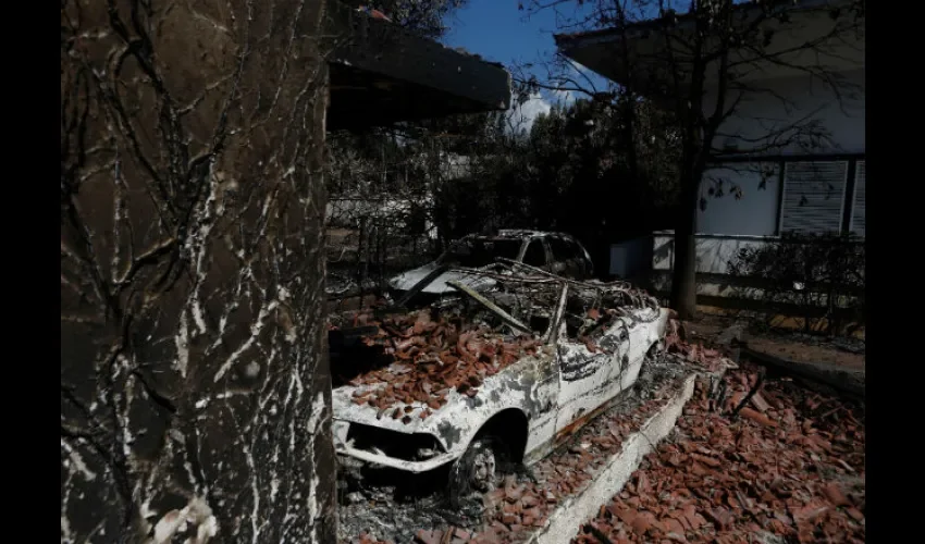Vista de una vivienda y vehículo afectados por el incendio forestal de Mati. Foto: EFE