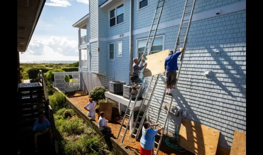 Las personas aseguran sus hogares ante el paso inminente del huracán. Foto: EFE