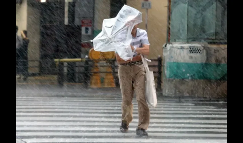Este señor intenta protegerse de la lluvia. Foto: EFE