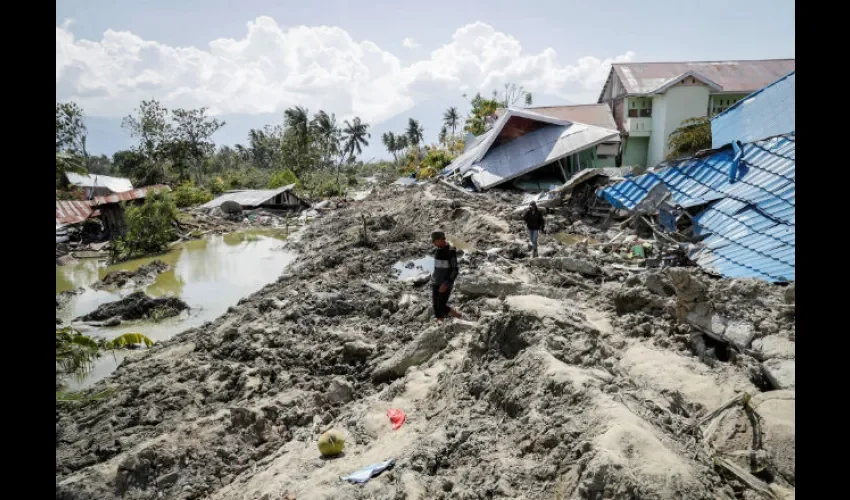 Varias personas caminan entre las calles devastadas de Palu (Indonesia). Foto: EFE