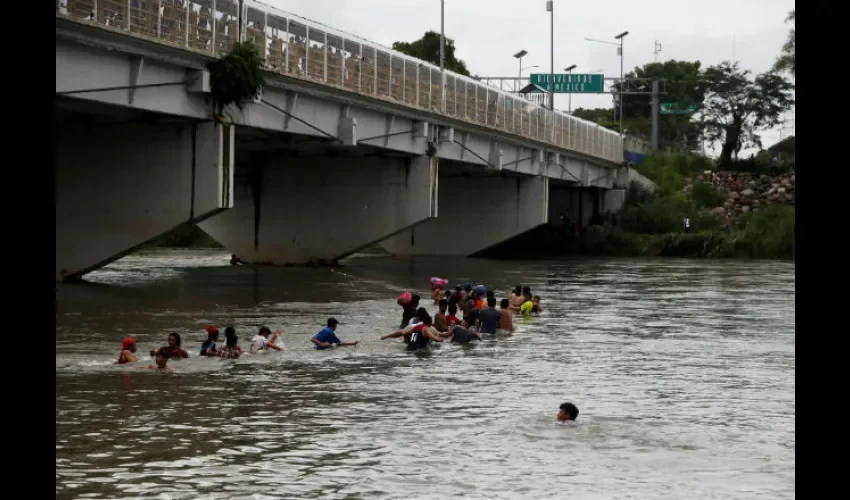 Decenas de migrantes hondureños cruzan a pie el río Suchiate. Foto: EFE