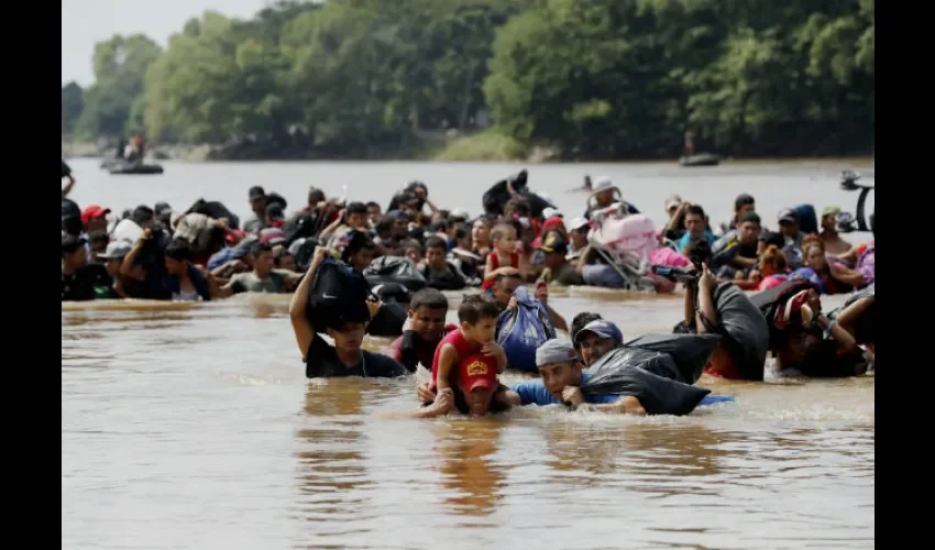 Integrantes de la segunda caravana de migrantes cruzan a pie el río Suchiate por una parte que no es muy profunda. Foto: EFE