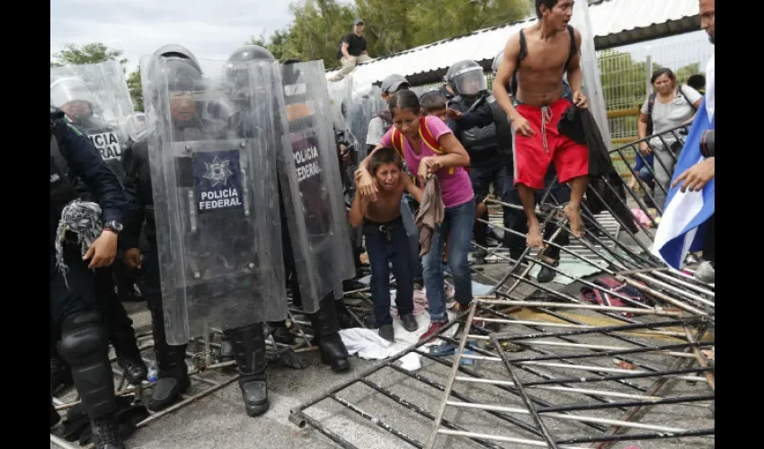 Migrantes hondureños rompen las rejas y cruzan la frontera con México. Foto: EFE