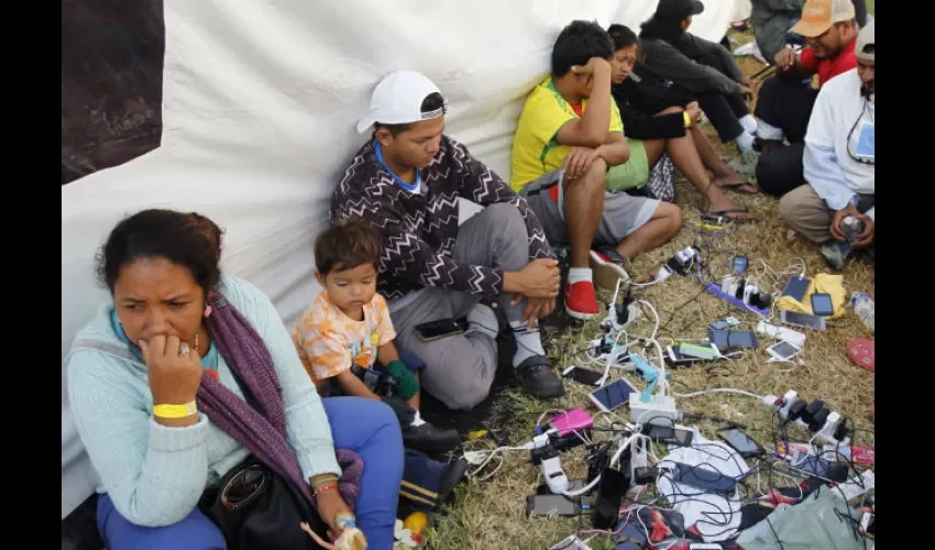 Grupos de personas de la caravana migrantes recargan sus celulares , en el deportivo Jesús Martínez Palillo, en Ciudad de México (México). EFE 