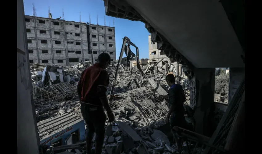  Un par de palestinos caminan entre los escombros de un edificio del canal de televisión Al Aqsa tras un ataque aéreo israelí en la ciudad de Gaza. EFE/ Mohammed Saber
