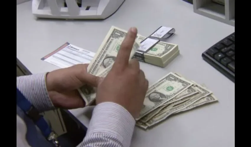 Foto ilustrativa de la entrega de dinero en el banco. 