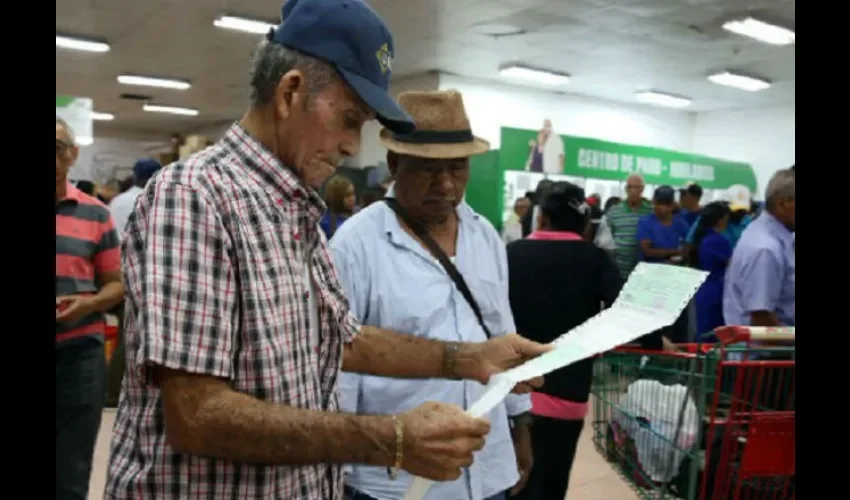 Foto ilustrativa de jubilados recibiendo sus cheques. 