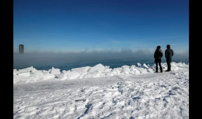 Una pareja observa el vapor causado por las bajas temperaturas en el lago Michigan. Foto: EFE