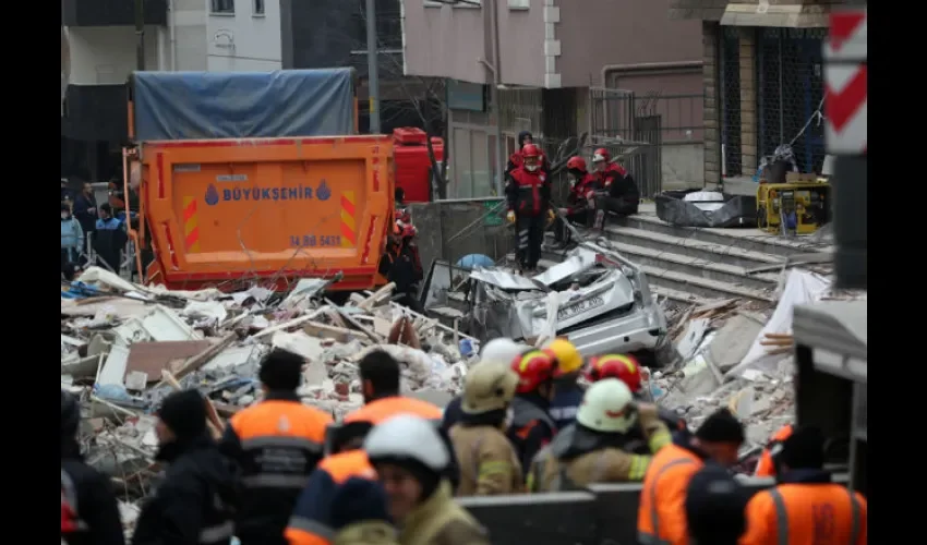Varios miembros de los servicios de rescate se toman un descanso mientras continúan con las labores de búsqueda de supervivientes  tras el derrumbe de un edificio en el distrito de Kartal, en Estambul. EFE