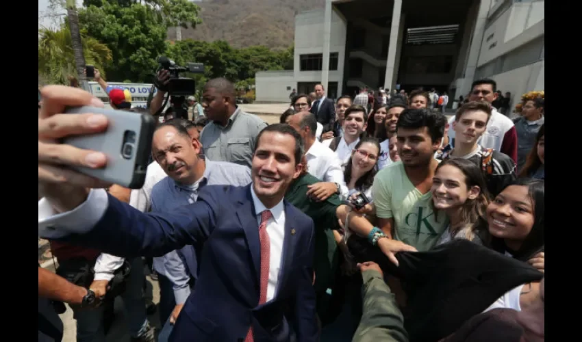 El jefe del Parlamento venezolano, Juan Guaidó (c), reconocido como presidente interno del país por más de 50 naciones, posa para una selfi con varios simpatizantes durante la presentación del Plan País en el área de Seguridad. EFE 