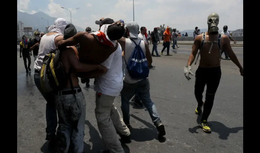 Un grupo de personas cargan un herido durante una manifestación en apoyo al presidente de la Asamblea Nacional, Juan Guaidó, frente al gobierno de Nicolás Maduro este martes, en Caracas (Venezuela). EFE 