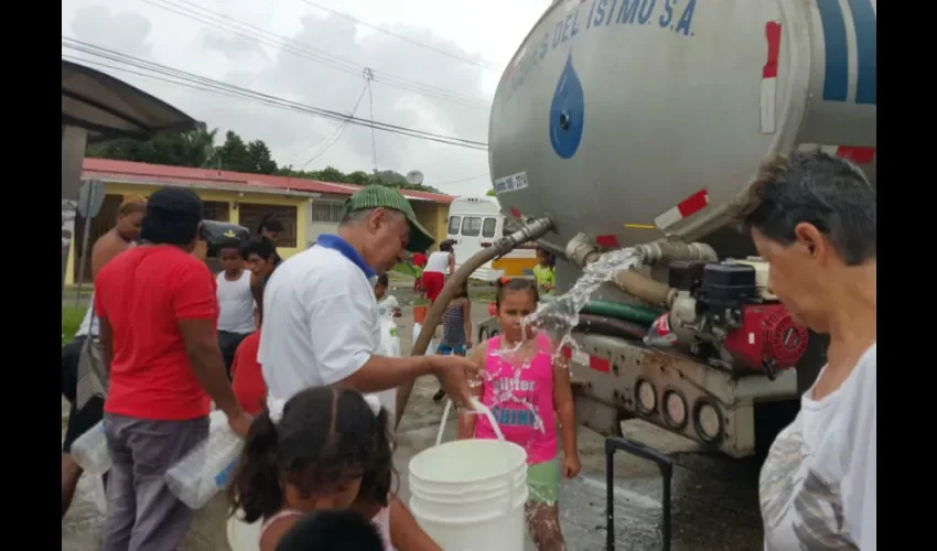 Foto ilustrativa de un grupo de moradores recolectando agua gracias al carro cisterna. 