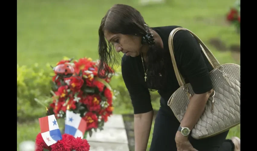 Una joven al pie de la tumba de uno de los fallecidos. AP/Arnulfo Franco