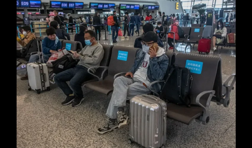Wuhan (China), 07/04 / 2020.- Los pasajeros con máscaras protectoras esperan en el aeropuerto después de que se levantó el encierro en Wuhan, China, el 8 de abril de 2020. Wuhan, el epicentro del brote de coronavirus, levantó el encierro el 08 de abril 2020, que permite a las personas salir de la ciudad después de más de dos meses. Según cifras del gobierno chino, más de 2.500 personas han muerto de Covid-19 en Wuhan desde que comenzó el brote. EFE / EPA / ROMAN PILIPEY.