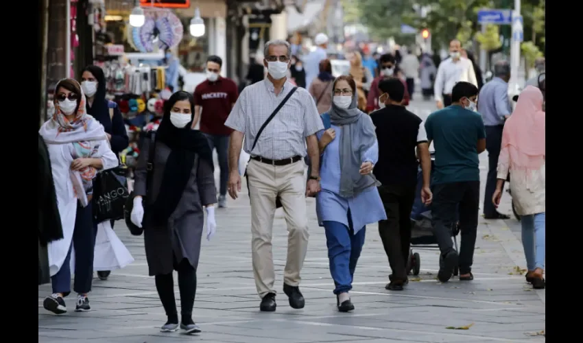 Los iraníes con máscaras faciales caminan por una calle de Teherán, Irán, el 27 de julio de 2020. 