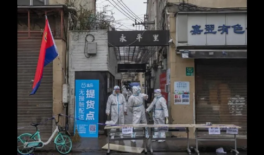 Sanitarios a la entrada de un barrio de Shanghai cerrado por la incidencia del coronavirus. EFE