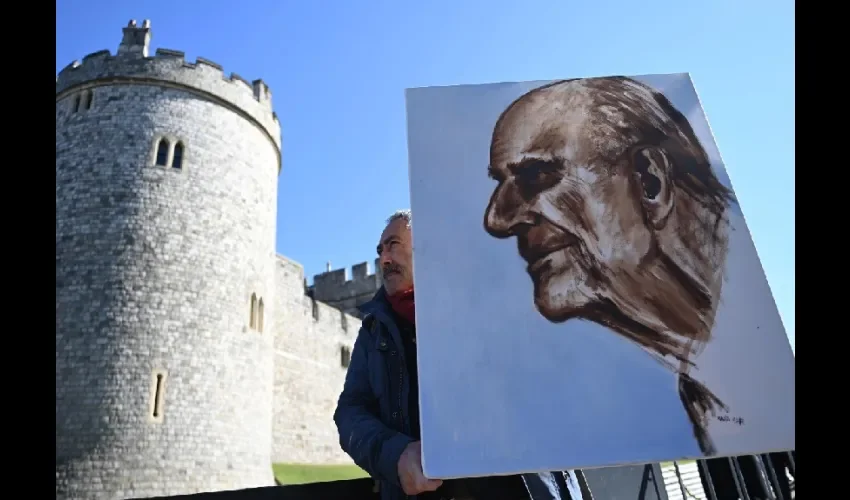 El artista Kaya Marr sostiene un retrato del príncipe Felipe, duque de Edimburgo, frente al castillo de Windsor en Windsor, Gran Bretaña. EFE 