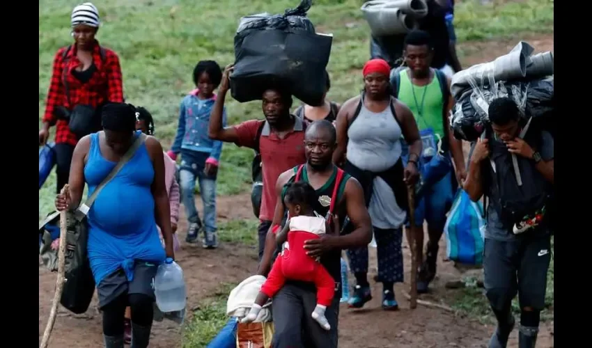 Fotografía del 28 de septiembre de 2021 que muestra a migrantes haitianos en su camino hacia Panamá por el Tapón del Darién en Acandi (Colombia). EFE.