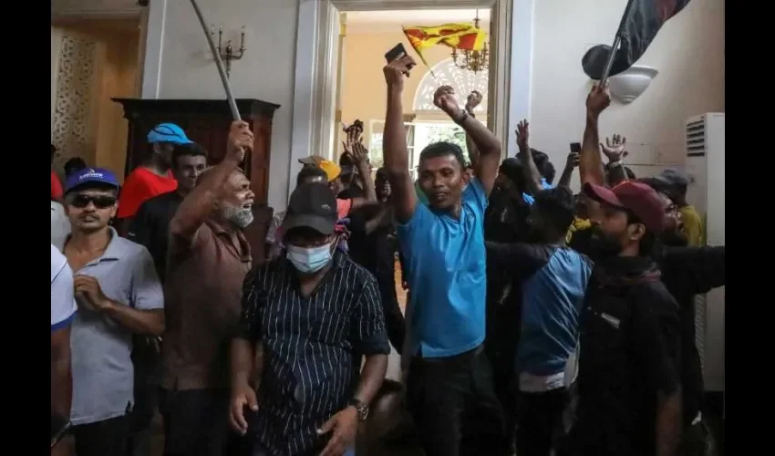 Los manifestantes aplauden dentro de las instalaciones de la residencia oficial del presidente en Colombo, Sri Lanka, el 9 de julio de 2022. EFE.