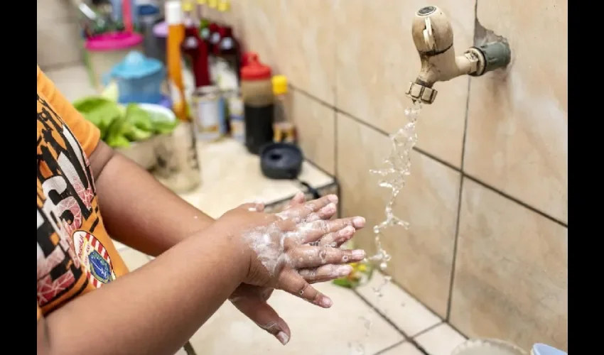 Vista de un niño lavándose las manos.