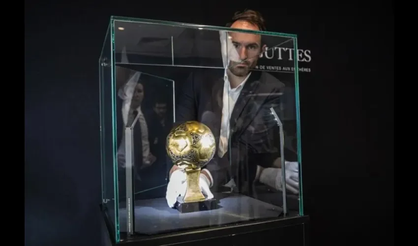 Francois Thierry, experto en deportes de la casa de subastas Aguttes, presenta el trofeo del Balón de Oro de Diego Maradona del Mundial de 1986. EFE/EPA/Christophe Petit Tesson