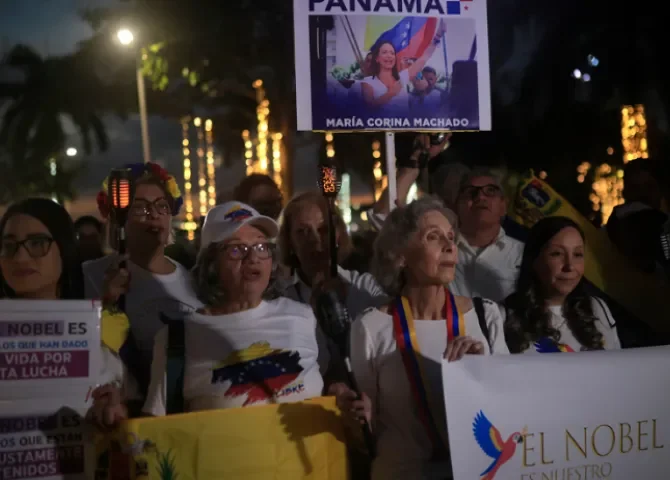  Personas sostienen carteles durante la marcha "por la paz y la libertad" en Venezuela este sábado, en Ciudad de Panamá (Panamá). Foto: EFE.  